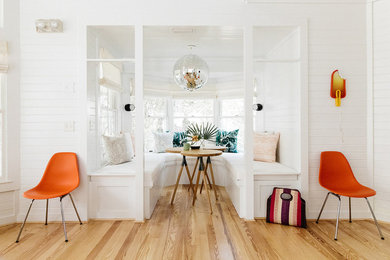 Small beach style light wood floor and brown floor great room photo in Other with white walls and no fireplace