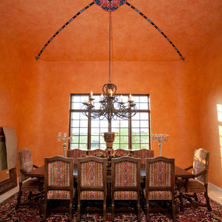 Immagine di una grande sala da pranzo aperta verso la cucina mediterranea con pareti arancioni, moquette e nessun camino