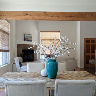 Ejemplo de comedor de estilo americano, pequeño, cerrado, con paredes blancas, suelo de madera en tonos medios, chimenea de esquina, marco de chimenea de baldosas y/o azulejos y suelo marrón