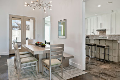Ispirazione per una grande sala da pranzo aperta verso la cucina design con pareti bianche, pavimento in cemento e pavimento marrone