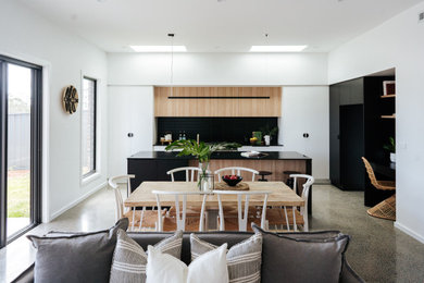 На фото: гостиная-столовая среднего размера в современном стиле с бетонным полом, серым полом и белыми стенами