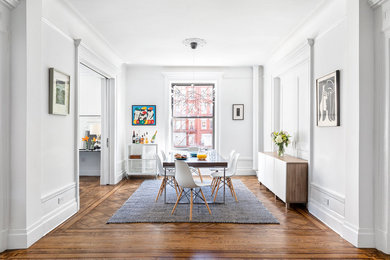 This is an example of a medium sized traditional dining room in New York with white walls, medium hardwood flooring, brown floors and a coffered ceiling.