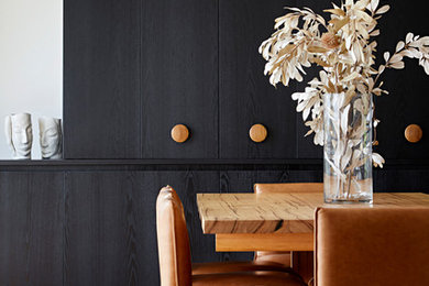 Modelo de comedor contemporáneo de tamaño medio abierto con paredes negras, suelo de madera en tonos medios y suelo marrón