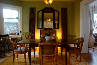 Idées déco pour une petite salle à manger ouverte sur la cuisine éclectique avec un mur vert et un sol en bois brun.