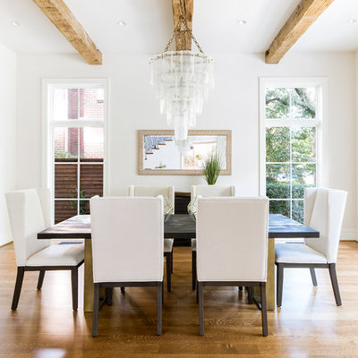 Transitional medium tone wood floor enclosed dining room photo in Dallas with white walls