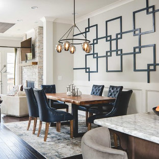 Ispirazione per una sala da pranzo aperta verso la cucina classica di medie dimensioni con pareti grigie, parquet scuro, camino classico, cornice del camino in pietra e pavimento marrone