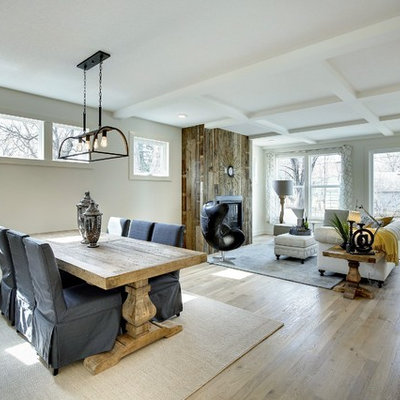 Great room - mid-sized cottage light wood floor great room idea in Minneapolis with white walls, a standard fireplace and a wood fireplace surround