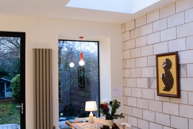 Foto de comedor moderno de tamaño medio abierto con paredes blancas, suelo gris y suelo de baldosas de porcelana