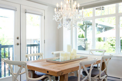 Exemple d'une salle à manger ouverte sur la cuisine chic de taille moyenne avec un mur blanc, un sol en bois brun et aucune cheminée.