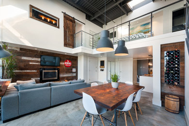 Inspiration for an industrial concrete floor great room remodel in Vancouver with white walls