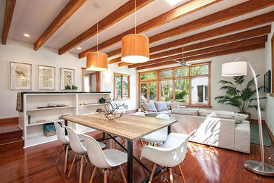 This is an example of a beach style open plan dining room in Los Angeles with white walls and medium hardwood flooring.