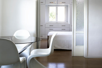 Immagine di una piccola sala da pranzo aperta verso il soggiorno contemporanea con pareti bianche, parquet chiaro e nessun camino