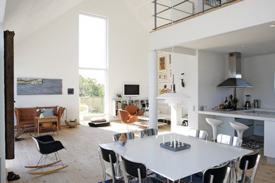 This is an example of a large contemporary open plan dining room in Aalborg with white walls and light hardwood flooring.