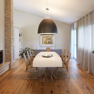 Esempio di un'ampia sala da pranzo contemporanea con pareti beige, pavimento in legno massello medio, camino classico, pavimento marrone e cornice del camino in pietra