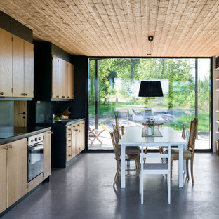 Foto på ett mellanstort nordiskt kök med matplats, med betonggolv, grått golv och svarta väggar