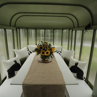 Immagine di una piccola sala da pranzo aperta verso la cucina country con pareti verdi e pavimento in laminato
