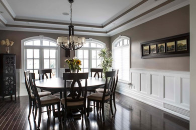 Inspiration for a large transitional dark wood floor enclosed dining room remodel in Toronto with brown walls