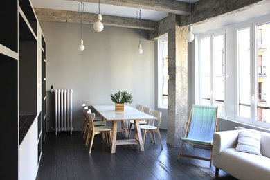 Ispirazione per una sala da pranzo aperta verso il soggiorno industriale di medie dimensioni con pareti grigie, pavimento in legno verniciato e nessun camino
