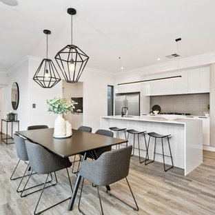 Photo of a contemporary kitchen/dining combo in Perth with white walls and light hardwood floors.