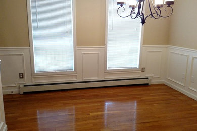 Inspiration for a mid-sized timeless light wood floor enclosed dining room remodel in Manchester with beige walls