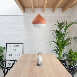This is an example of a contemporary dining room in London with white walls.