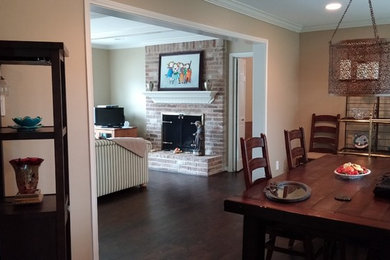 Example of a mid-sized classic dark wood floor enclosed dining room design in Houston with beige walls, a standard fireplace and a brick fireplace