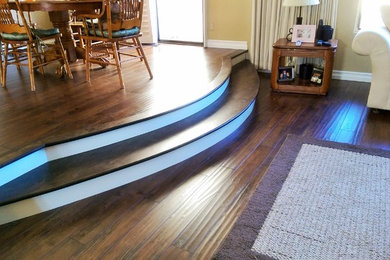 Example of a mid-sized mountain style laminate floor and brown floor great room design in Los Angeles with brown walls