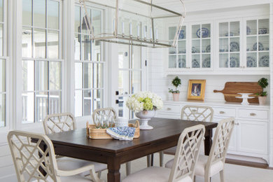 Foto di una sala da pranzo aperta verso la cucina stile marinaro di medie dimensioni con pareti bianche, pavimento in legno massello medio, nessun camino e pavimento marrone