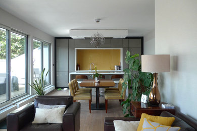 Imagen de comedor contemporáneo grande abierto con paredes grises, suelo de madera en tonos medios y suelo marrón