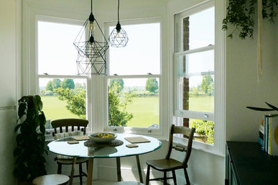 Aménagement d'une petite salle à manger ouverte sur la cuisine contemporaine avec un mur blanc, parquet peint et un sol blanc.