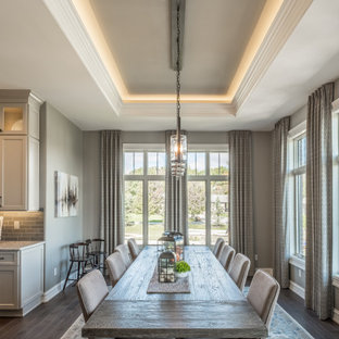 Bild på en stor lantlig matplats med öppen planlösning, med beige väggar, mörkt trägolv och brunt golv