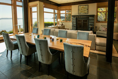 シアトルにある高級な広いビーチスタイルのおしゃれなLDK (ベージュの壁、スレートの床、標準型暖炉、タイルの暖炉まわり、グレーの床) の写真