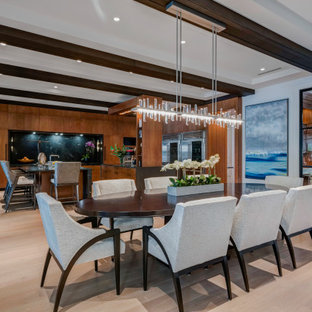 Immagine di una sala da pranzo aperta verso il soggiorno design di medie dimensioni con pareti beige, parquet chiaro, pavimento beige e travi a vista