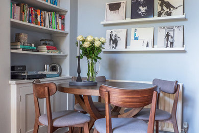 Ispirazione per una piccola sala da pranzo aperta verso il soggiorno contemporanea con pareti blu, pavimento in legno massello medio e pavimento marrone