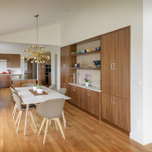 Example of a mid-century modern medium tone wood floor and brown floor great room design in Seattle with white walls