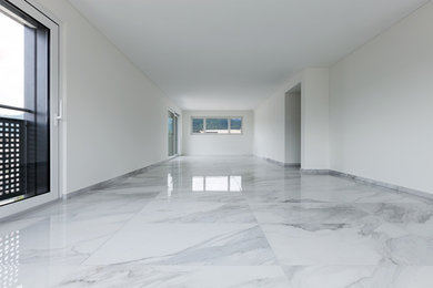 This is an example of a large contemporary dining room in Tampa with white walls and marble flooring.