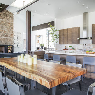 Cette image montre une salle à manger ouverte sur le salon design avec un mur blanc et un sol en bois foncé.