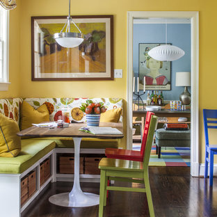 Foto di una sala da pranzo aperta verso la cucina boho chic di medie dimensioni con pareti gialle, parquet scuro e nessun camino