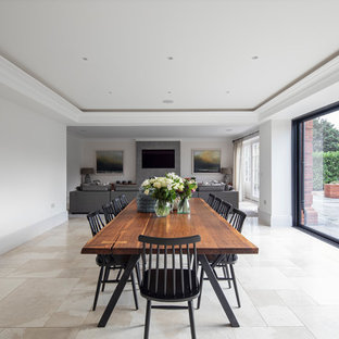 Traditional open plan dining room in Other with white walls and beige floors.