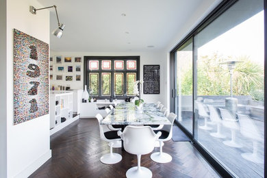 Medium sized contemporary dining room in London with white walls, dark hardwood flooring, brown floors and no fireplace.