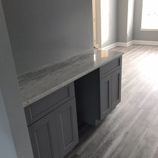 Cette image montre une grand salle à manger ouverte sur le salon rustique avec un sol en vinyl, un sol gris, un mur gris et aucune cheminée.