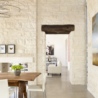 Ispirazione per una sala da pranzo mediterranea con camino bifacciale e cornice del camino in pietra