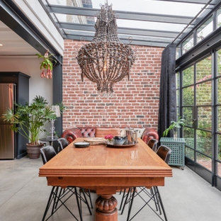 Aménagement d'une salle à manger industrielle avec un plafond voûté et un mur en parement de brique.