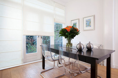 Mid-sized trendy light wood floor and beige floor enclosed dining room photo in Raleigh with white walls and no fireplace