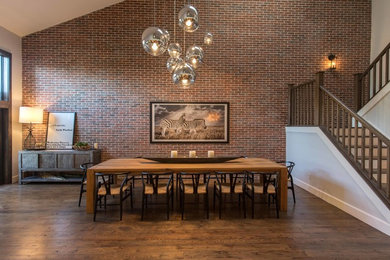 Esempio di una grande sala da pranzo aperta verso il soggiorno eclettica con pareti grigie, pavimento in legno massello medio e nessun camino
