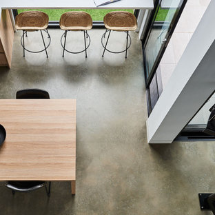 Ispirazione per un piccolo angolo colazione contemporaneo con pareti bianche, pavimento in cemento, pavimento grigio e soffitto a volta