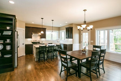 Example of a large cottage medium tone wood floor kitchen/dining room combo design in Cedar Rapids with beige walls and no fireplace