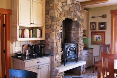 Inspiration for a rustic brick floor great room remodel in Minneapolis with beige walls, a wood stove and a stone fireplace
