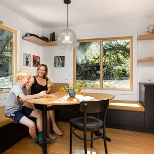 Foto på en mellanstor skandinavisk matplats med öppen planlösning, med vita väggar, mellanmörkt trägolv och orange golv