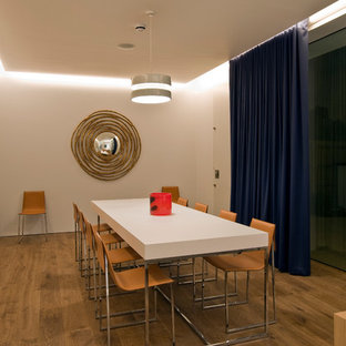 Photo of a medium sized modern dining room in London with white walls, light hardwood flooring and beige floors.